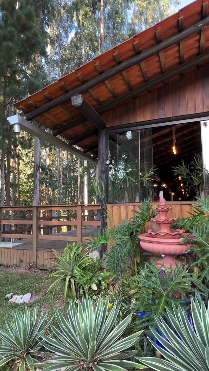 Salão de madeira do Espaço Liaris com fonte e jardim na frente